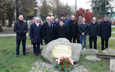 10. Złożenie wiązanki pod tablicą upamiętniającą wyw&oacute;zki na Sybir
